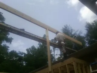 Carpenter setting a ridge beam over a new addition frame — Ice Dam Removal by Roofing Brothers in Nevis