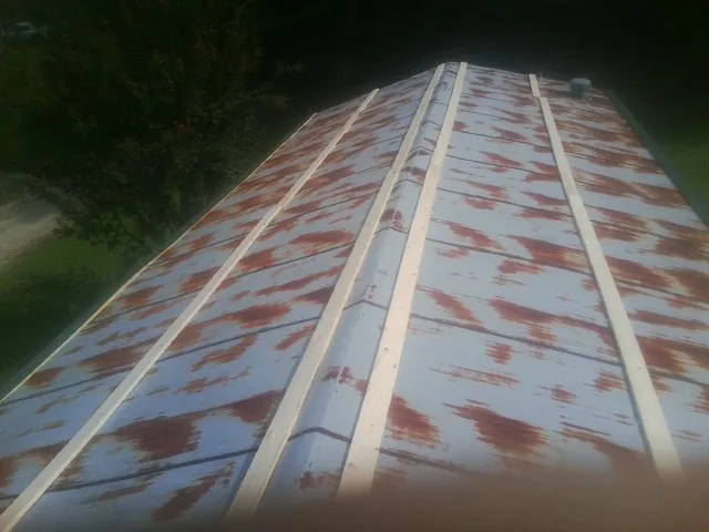 Rusted metal roof panels with new wood purlins before replacement — Storm Damage Roof Repair in Nevis by Roofing Brothers