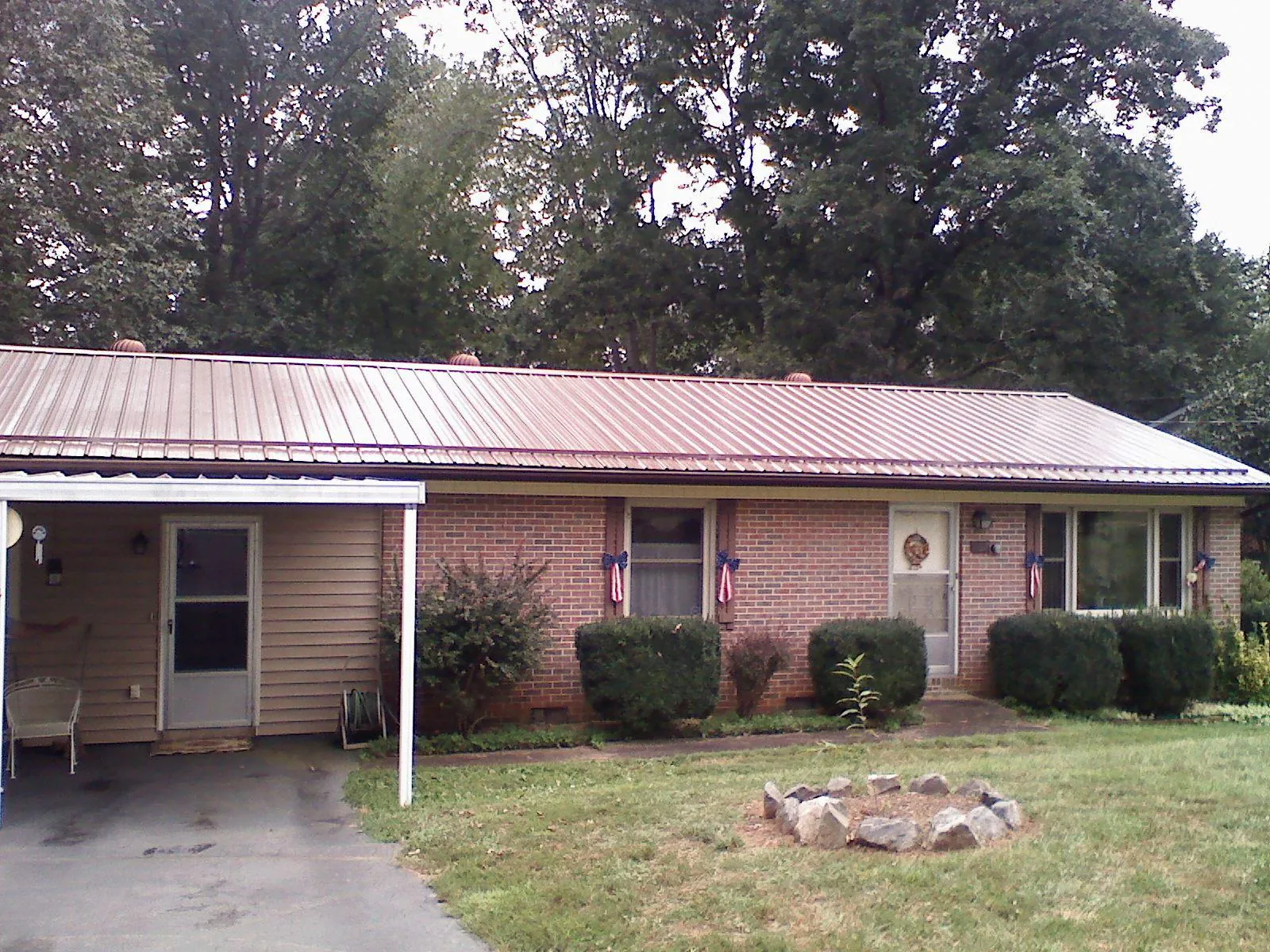 Bronze metal roof and carport on a brick ranch home — Roof Repair work by our crew in Nevis
